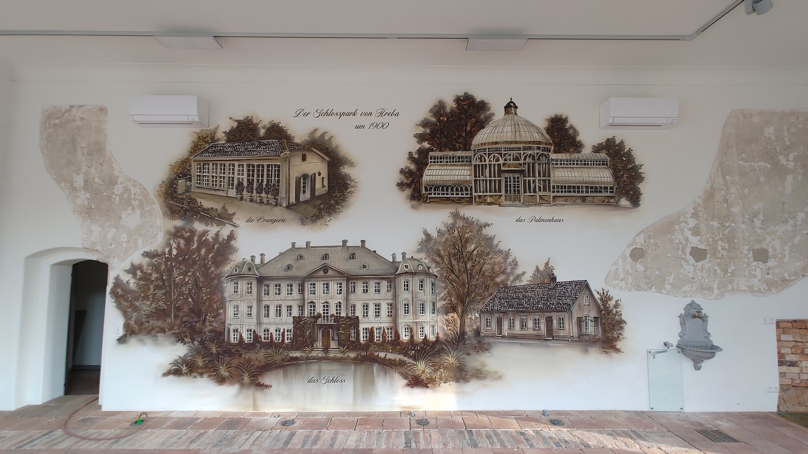 Wandgemälde in Brauntönen, das die Gebäude des Schlossparks um 1900 zeigt, daneben freigelegte alte Putzflächen